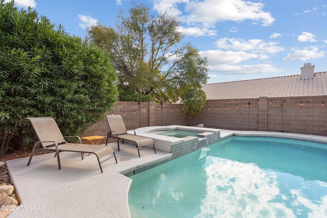 view of swimming pool with an in ground hot tub