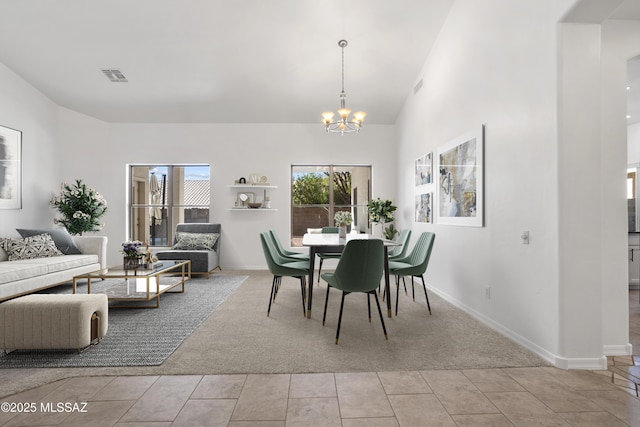 dining area with light carpet, a notable chandelier, and high vaulted ceiling