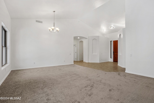 empty room with lofted ceiling, carpet flooring, and a chandelier