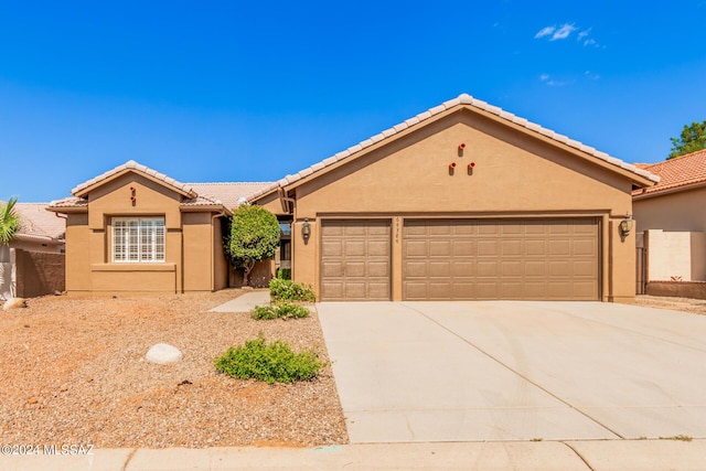 64384 E Round Robin Ln, Saddlebrooke, AZ 85739 - view of front of house featuring driveway, an attached garage, stucco siding, and a tile roof