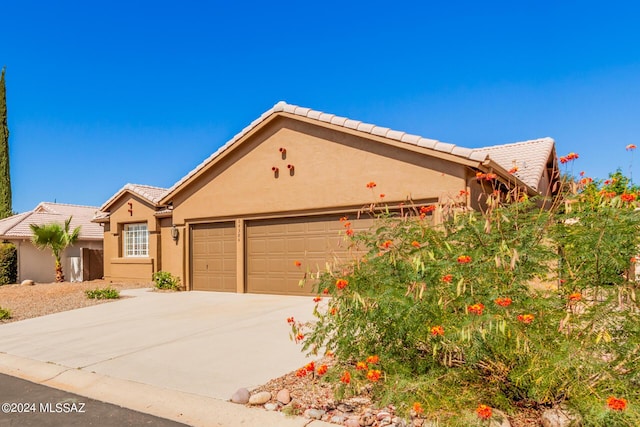 64384 E Round Robin Ln, Saddlebrooke, AZ 85739 - view of front facade featuring a garage, driveway, stucco siding, and a tiled roof