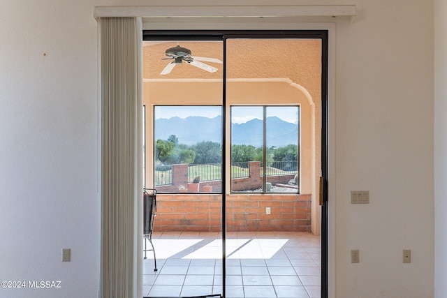 room details featuring ceiling fan, a mountain view, and tile patterned flooring