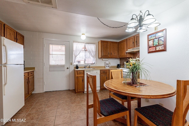 kitchen with a notable chandelier, white appliances, and light tile patterned floors