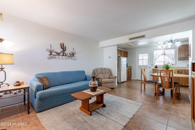 living room featuring light tile patterned flooring and a notable chandelier