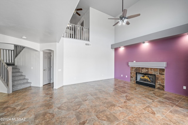 unfurnished living room featuring ceiling fan, a fireplace, and high vaulted ceiling