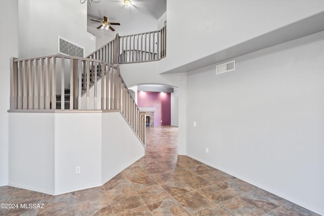 staircase with a high ceiling and ceiling fan