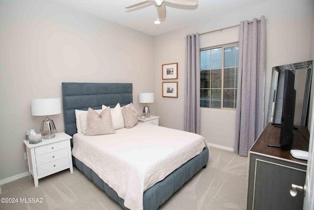 bedroom with ceiling fan, light carpet, and baseboards