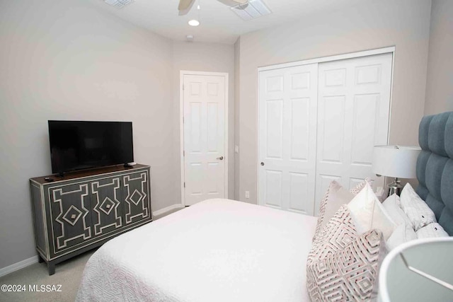 carpeted bedroom with visible vents, baseboards, a closet, and ceiling fan