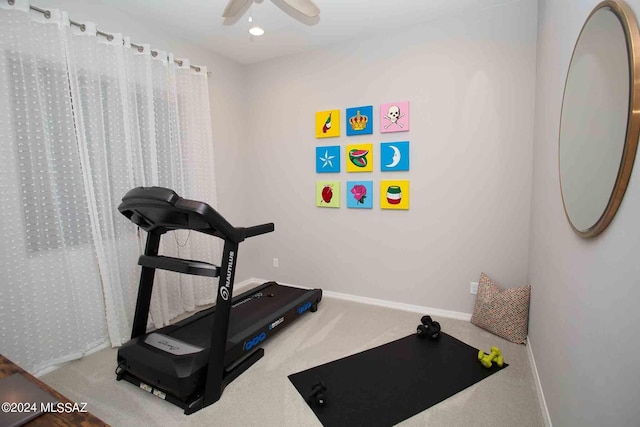 exercise room featuring baseboards, a ceiling fan, and carpet