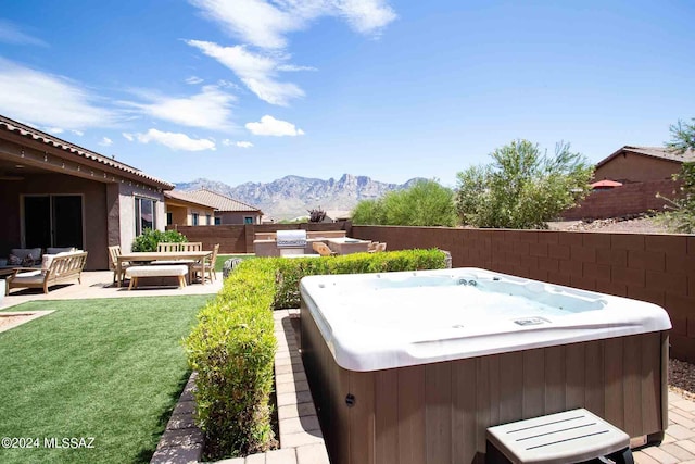 view of yard featuring a mountain view, fence, outdoor lounge area, a hot tub, and a patio