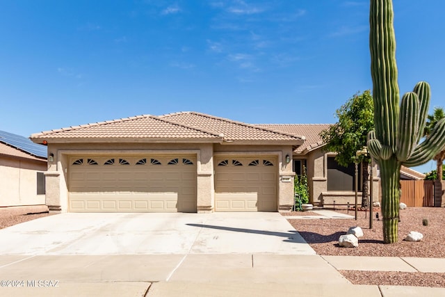 view of front of house featuring stucco siding, a garage, a tiled roof, and concrete driveway