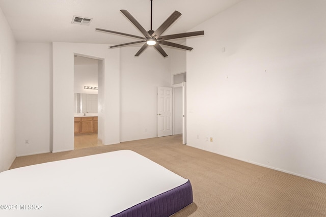 bedroom featuring high vaulted ceiling, ensuite bathroom, light colored carpet, visible vents, and ceiling fan