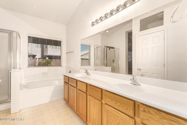 bathroom with vanity, shower with separate bathtub, and vaulted ceiling