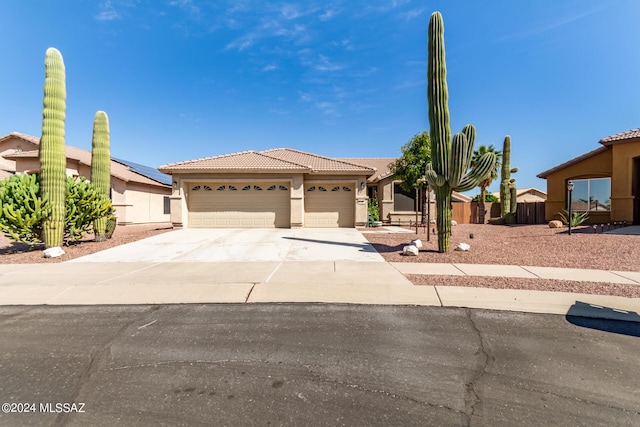 view of front of house featuring stucco siding, a tiled roof, a garage, and concrete driveway