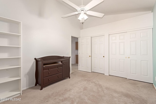 bedroom with multiple closets, lofted ceiling, a ceiling fan, and carpet