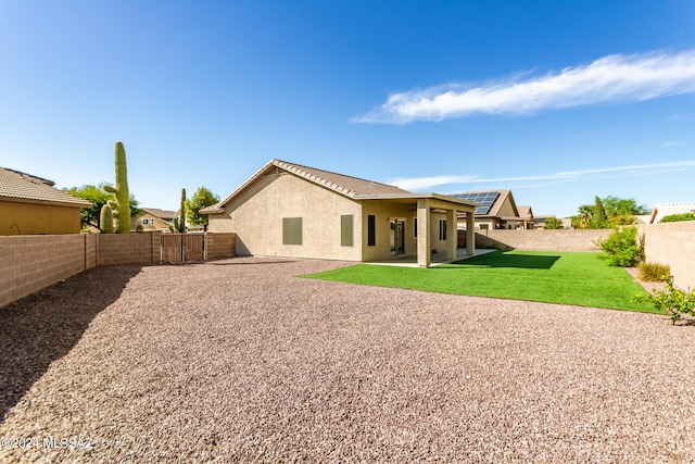 rear view of house featuring a yard and a patio area