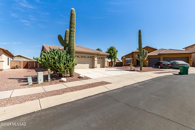 view of front of house with driveway, a tile roof, and a garage