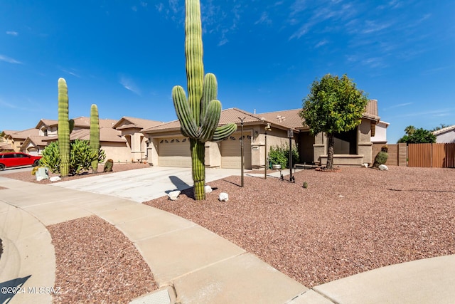 view of front of house with stucco siding, concrete driveway, a garage, and fence