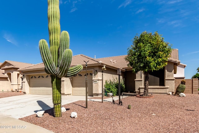 view of front of home featuring a tiled roof, stucco siding, an attached garage, and concrete driveway