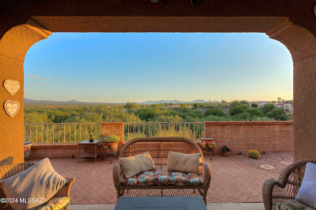 patio terrace at dusk featuring a mountain view and an outdoor hangout area