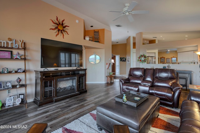 living room with a high ceiling, ceiling fan, and dark hardwood / wood-style floors