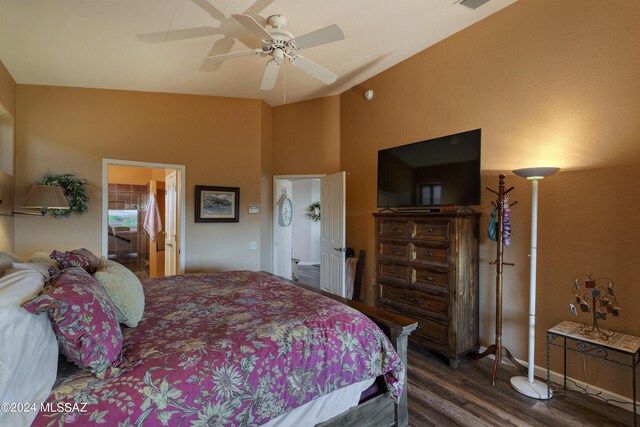 bedroom with ceiling fan, dark wood-type flooring, ensuite bathroom, and lofted ceiling