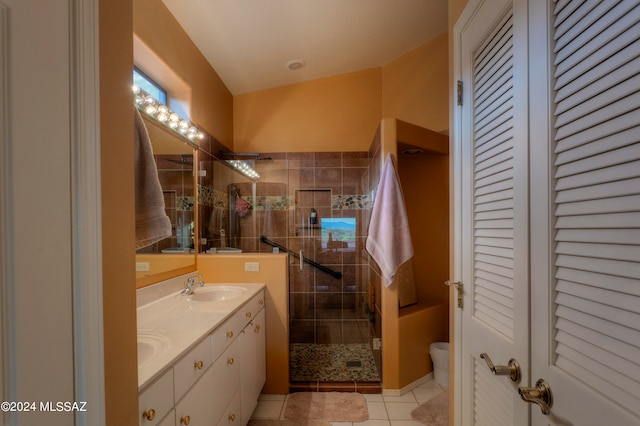 bathroom featuring vanity, toilet, tile patterned floors, and a shower with shower door