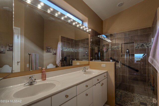 bathroom featuring vanity, a shower with shower door, and toilet