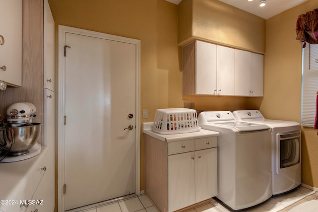 laundry area featuring washer and clothes dryer, cabinets, and light tile patterned flooring