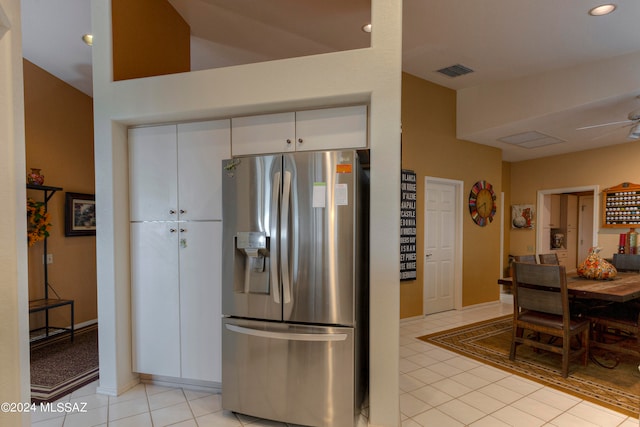 kitchen featuring stainless steel fridge, light tile patterned floors, white cabinetry, and ceiling fan