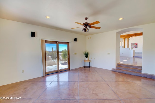 unfurnished room with arched walkways, concrete flooring, a ceiling fan, and recessed lighting