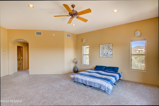 carpeted bedroom featuring arched walkways, visible vents, and recessed lighting