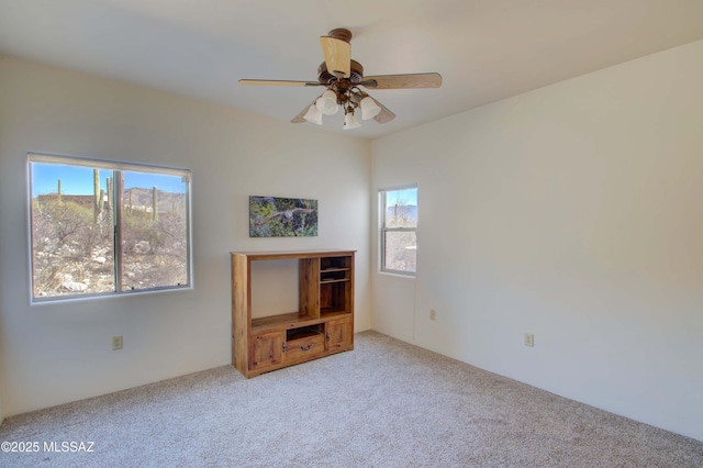 carpeted spare room with ceiling fan