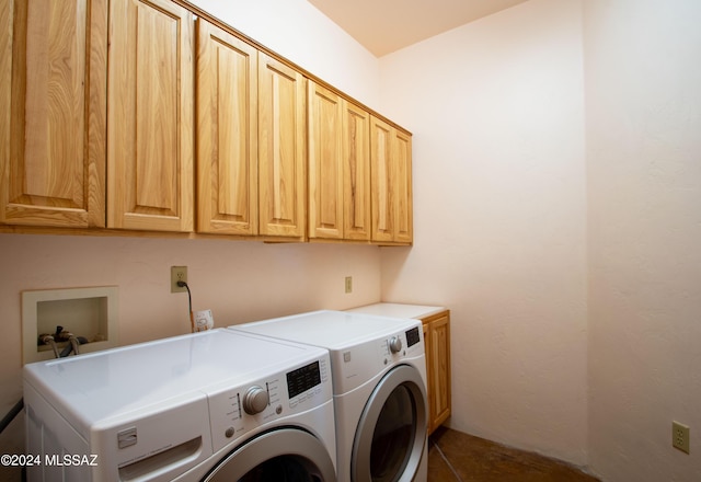 clothes washing area with washing machine and dryer and cabinet space