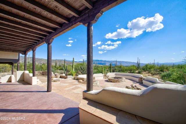 view of patio with an outdoor fire pit and a mountain view