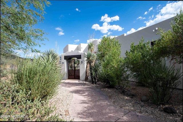 exterior space featuring a gate and stucco siding