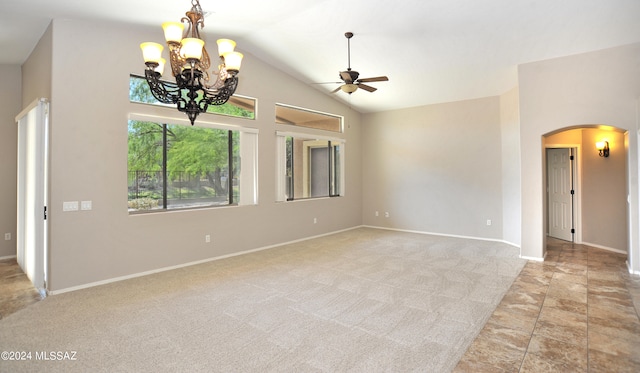 carpeted spare room featuring ceiling fan with notable chandelier and vaulted ceiling