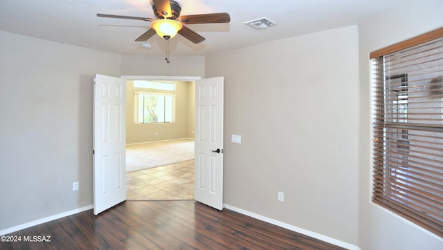 spare room with dark hardwood / wood-style floors and ceiling fan