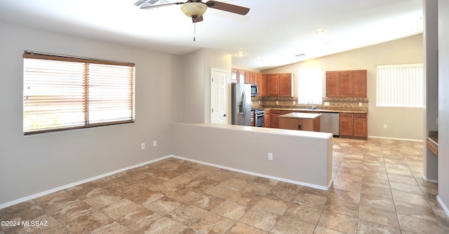 kitchen with ceiling fan, tasteful backsplash, kitchen peninsula, vaulted ceiling, and appliances with stainless steel finishes