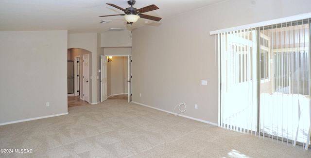 carpeted spare room featuring plenty of natural light and ceiling fan