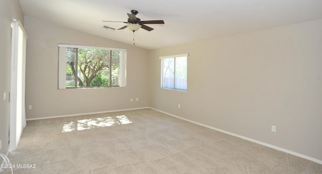 empty room featuring lofted ceiling, light carpet, and ceiling fan