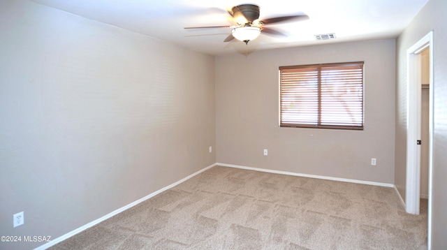 carpeted spare room with ceiling fan