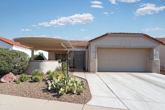 view of front facade featuring a tiled roof, an attached garage, driveway, and stucco siding