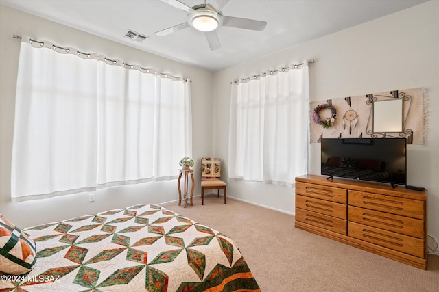 bedroom with visible vents, multiple windows, carpet floors, and a ceiling fan