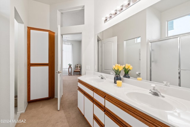 full bathroom with a high ceiling, double vanity, a sink, and a shower with door