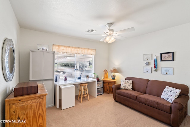 living area with light carpet, visible vents, and a ceiling fan