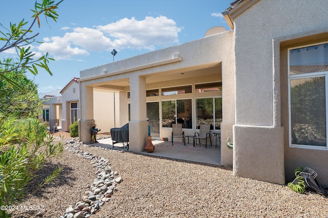 rear view of property with a patio and stucco siding