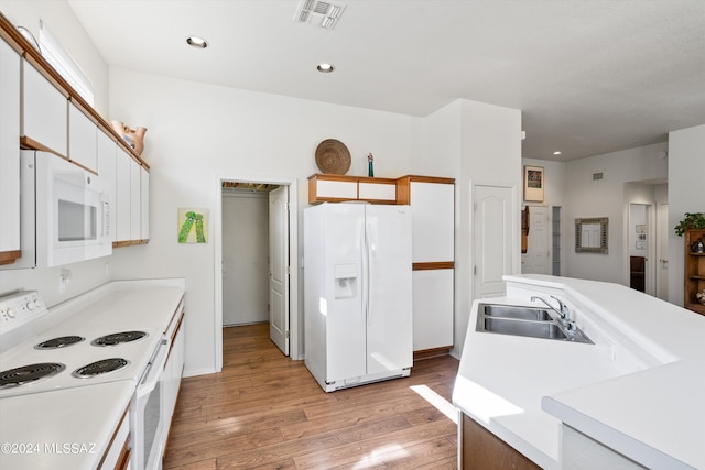 kitchen featuring visible vents, a sink, light countertops, white appliances, and light wood-style flooring