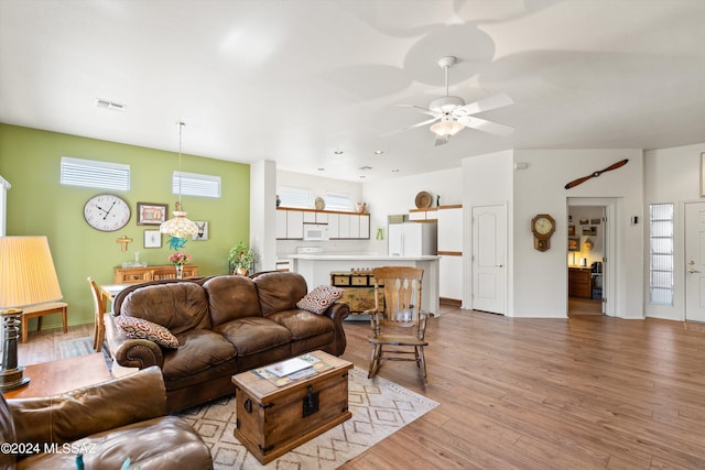 living room with light hardwood / wood-style floors and ceiling fan