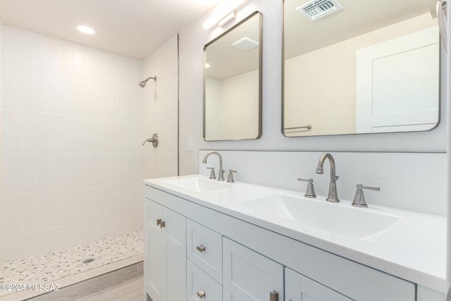 bathroom featuring vanity, hardwood / wood-style flooring, and tiled shower